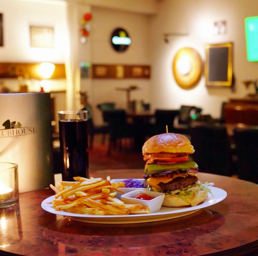 Clubhouse-Burger mit Pommes, Coleslaw und Kerze auf dem Tisch